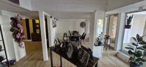 Intérieur lumineux d'une agence funéraire avec espace d'exposition de plaques et fleurs.