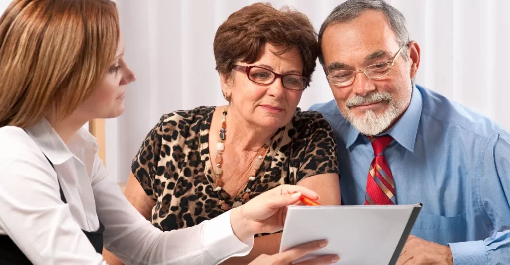 Couple senior en discussion pour un contrat d'obsèques avec une conseillère funéraire.